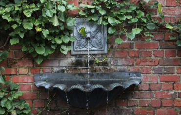 Alte Wasserfontaine an Ziegelwand