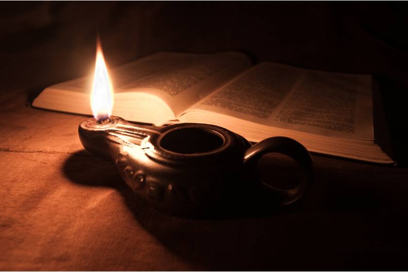 Antike Öllampe vor einer Bibel